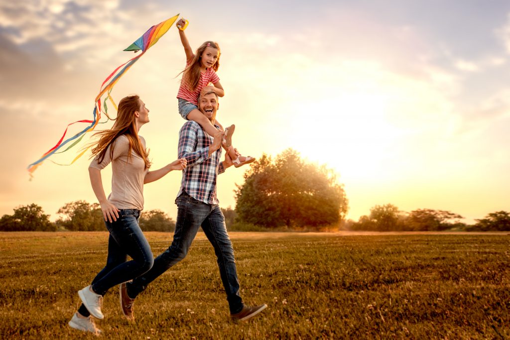 family,running,through,field,letting,kite,fly