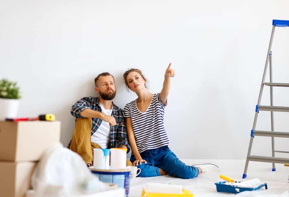 young,couple,woman,pointing,away,for,boyfriend,while,sitting,near