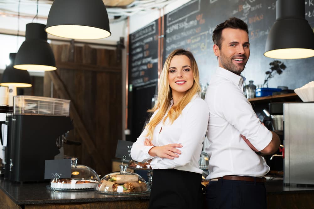 small,business,partners,standing,together,at,their,coffee,shop,,cafe