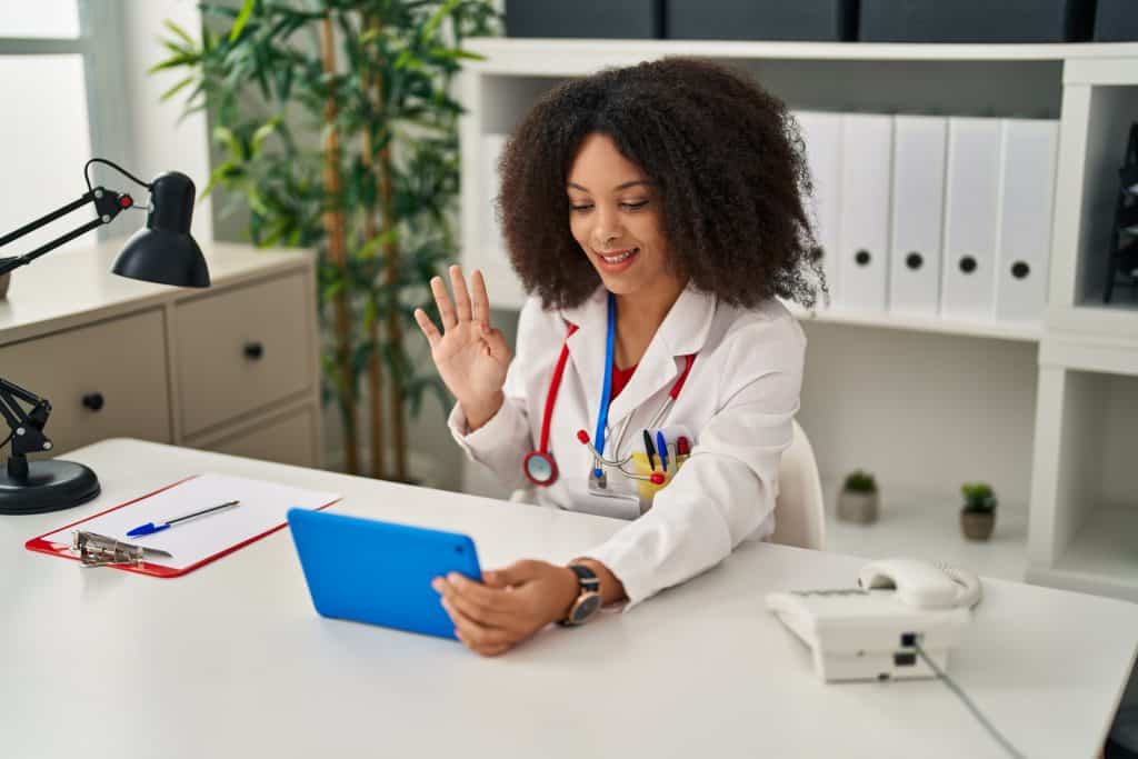 young,african,american,woman,wearing,doctor,uniform,having,teleconsultation,at