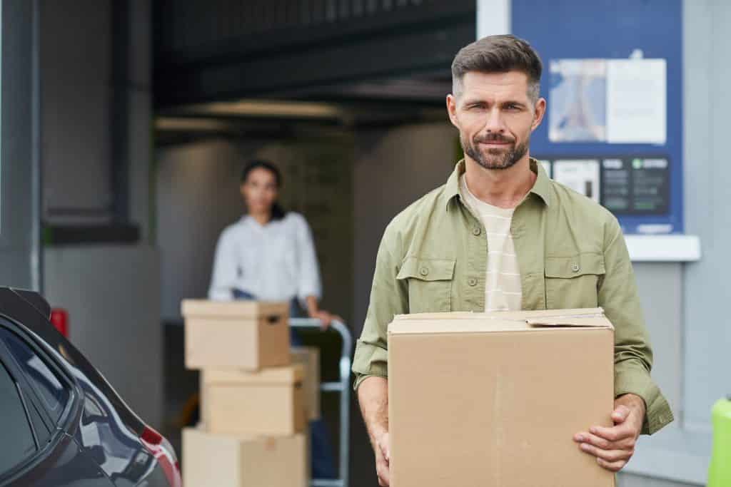 waist,up,portrait,of,handsome,man,holding,box,and,looking