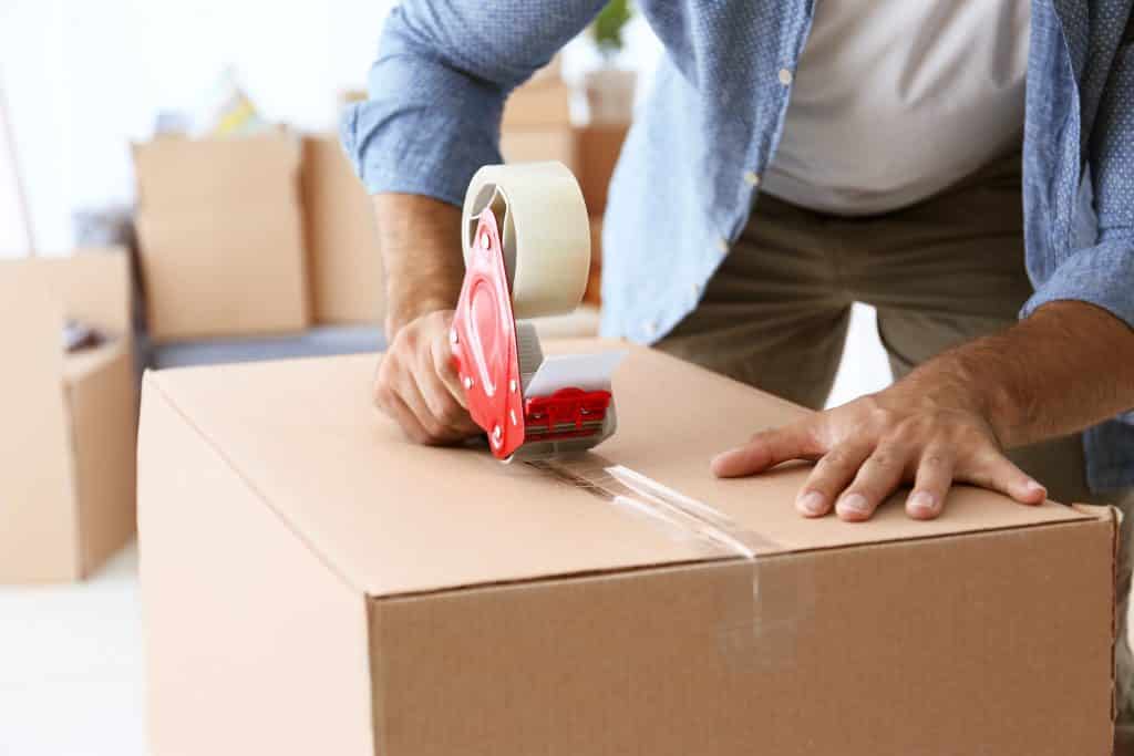 house,moving,concept.,closeup,of,man,packing,cardboard,box