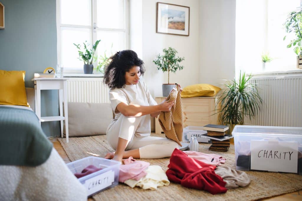 young,woman,sorting,wardrobe,indoors,at,home,,charity,donation,concept.