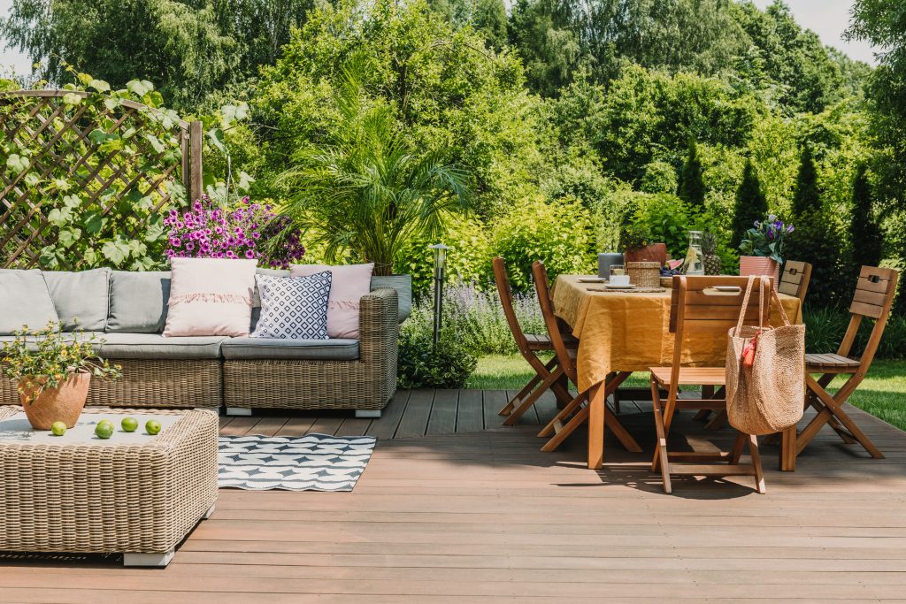 dining,table,covered,with,orange,tablecloth,standing,on,wooden,terrace