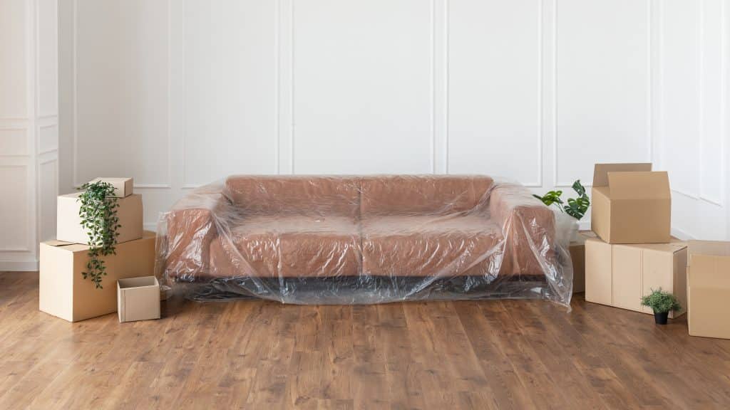 relocation,and,repair,concept.,modern,stylish,sofa,covered,with,plastic