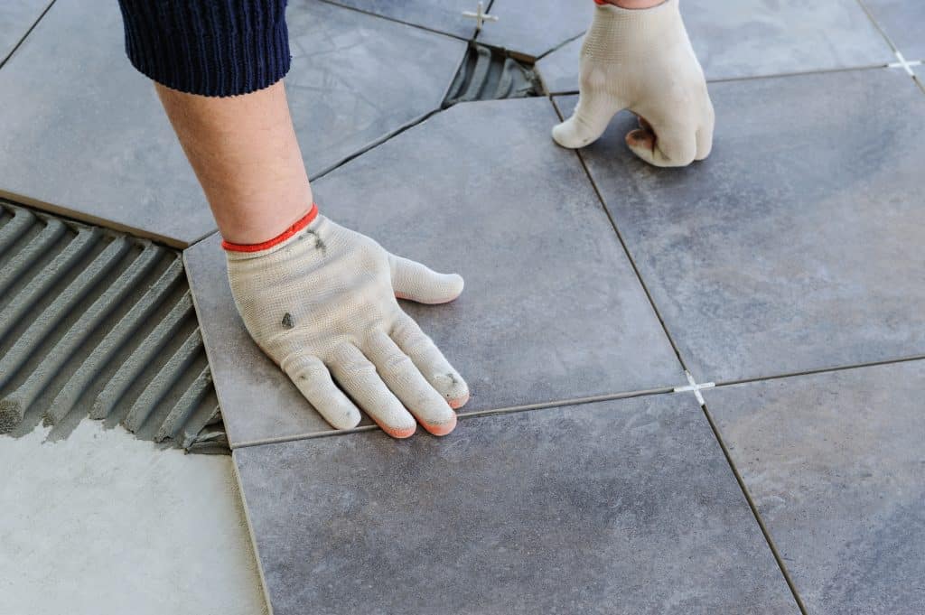 laying,ceramic,tiles.,worker,putting,tiles,on,the,balcony.