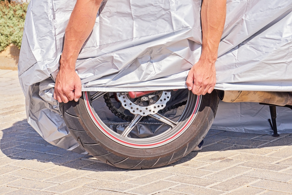 parked,outdoor,motorbike,covered,with,protective,fabric,shield,from,rain