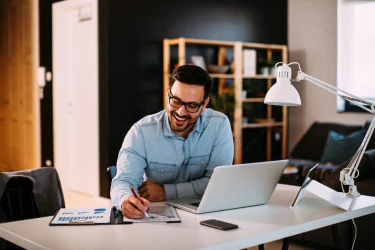 young,business,man,working,at,home,with,laptop,and,papers