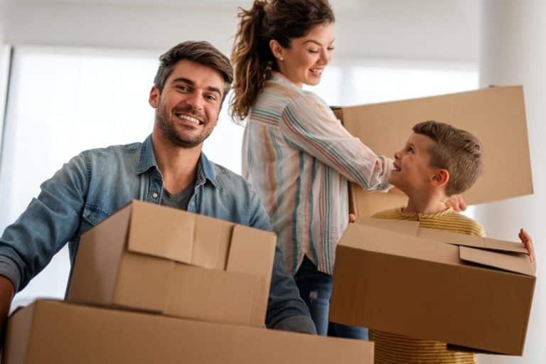 happy,family,with,cardboard,boxes,in,new,house,at,moving
