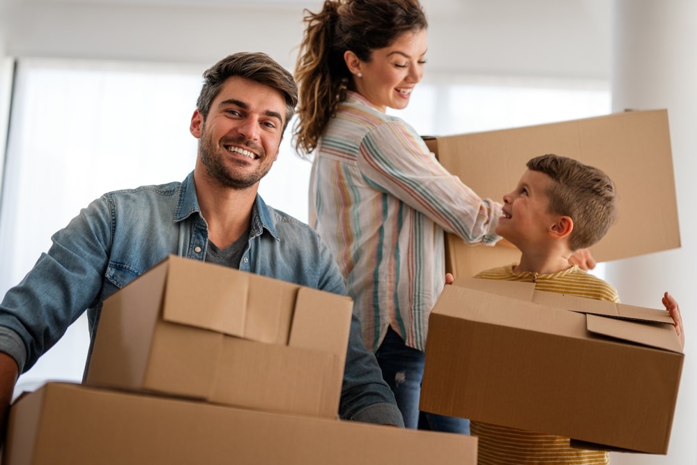 happy,family,with,cardboard,boxes,in,new,house,at,moving